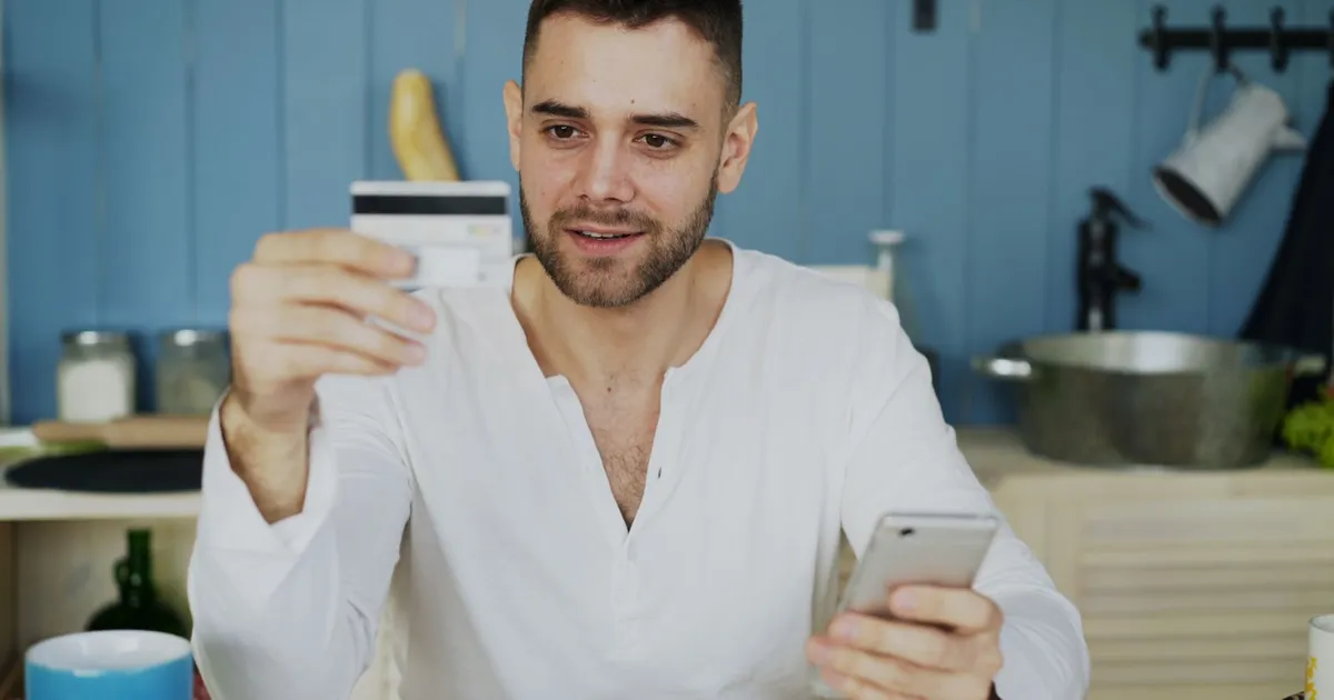 Person paying for a small purchase by phone after receiving a $500 loan no credit check