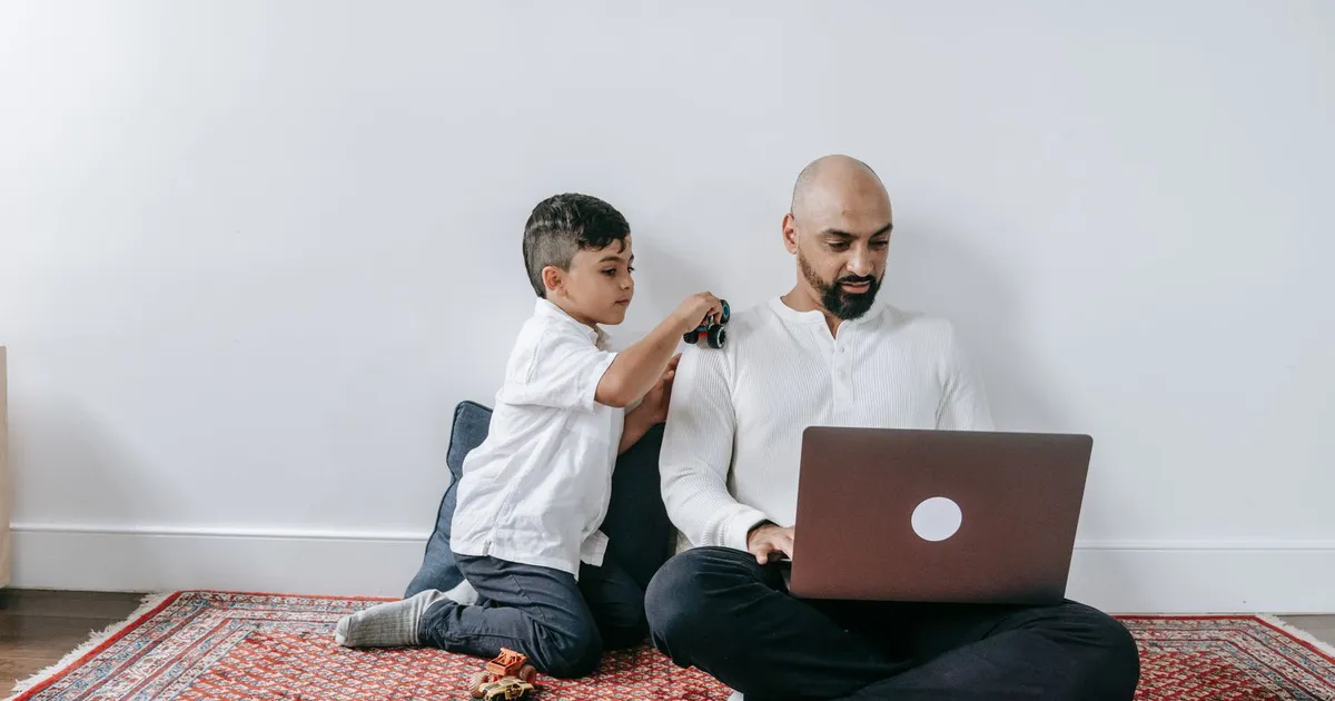 Parent reviewing no credit check loans on benefits with a child at the kitchen table on a laptop