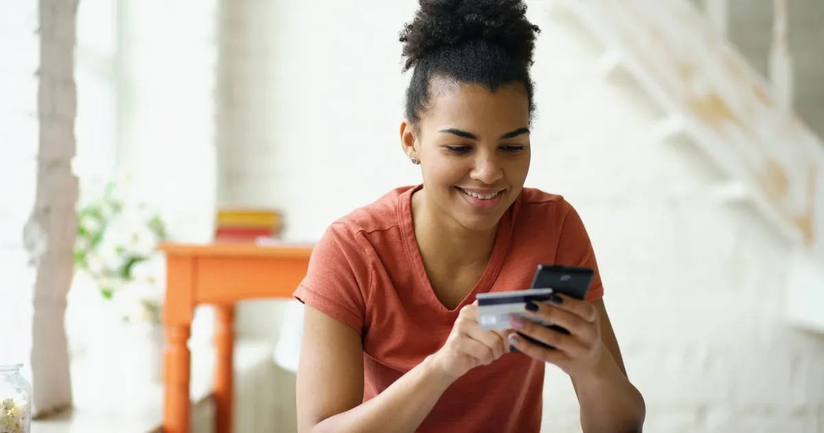 Canadian smiling at an e-transfer deposit from no credit check payday loans on a phone