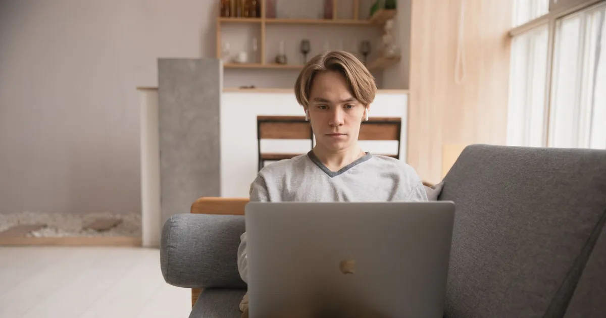 Person relaxed on a sofa applying for no income verification loans on a laptop