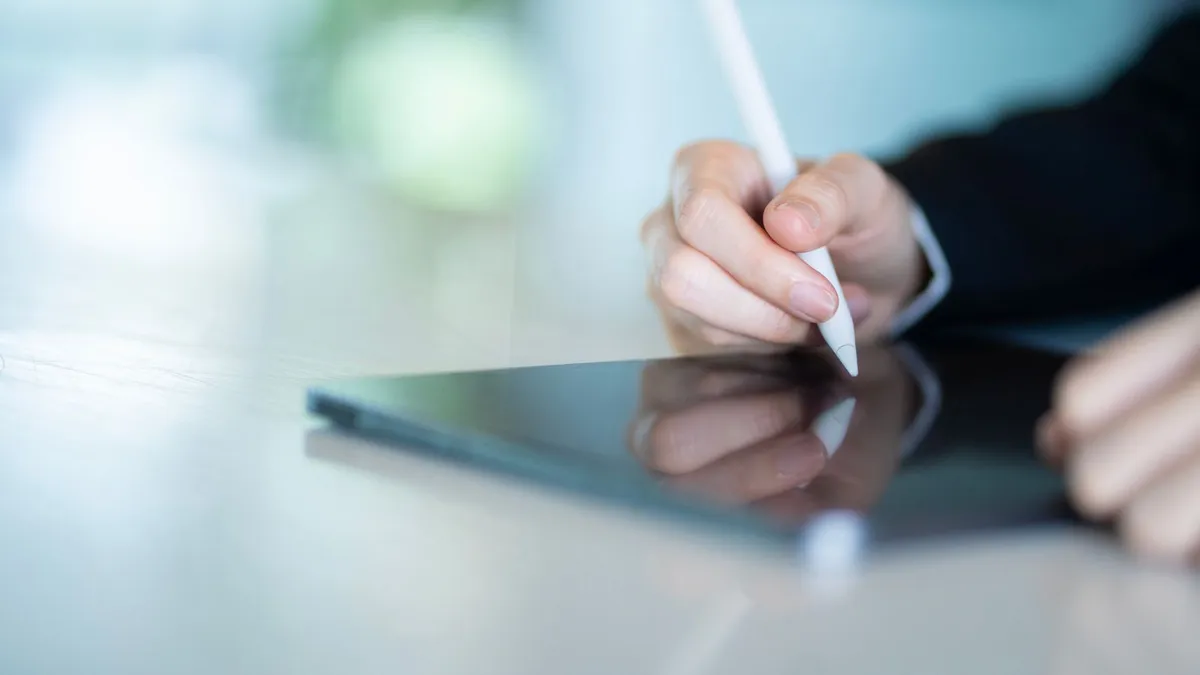 Paperless desk with a laptop showing an online loan agreement ready for e-signature